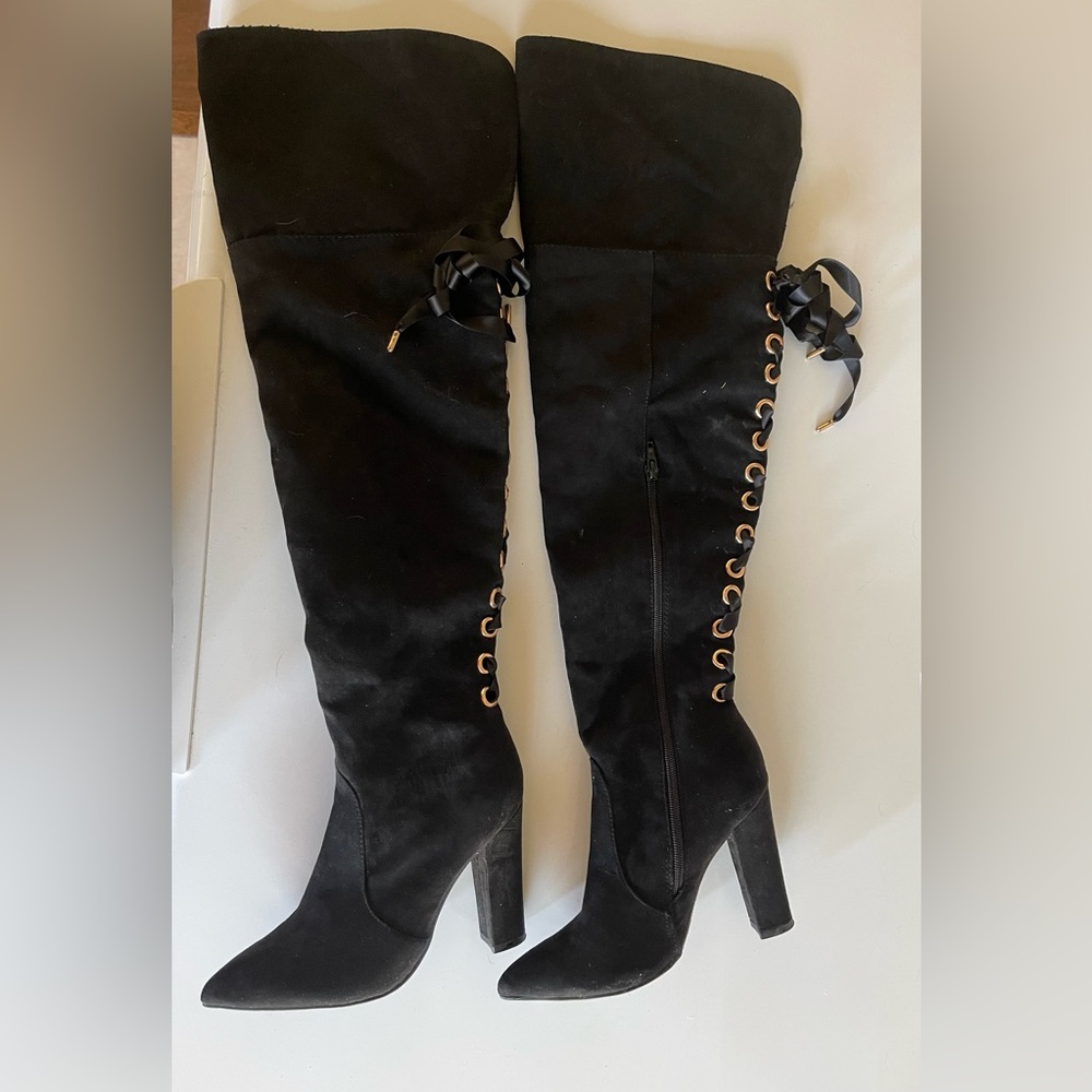Black suede thigh high boots with ribbon ties.
